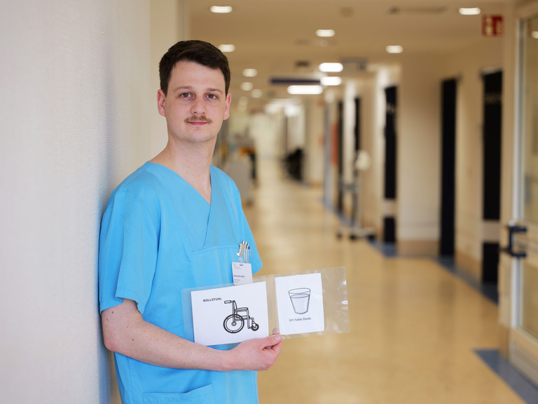 Kilian Müller, Stationsleitung der neurologischen Frührehabilitation im Albertinen Krankenhaus, zeigt Piktogramme zur Unterstützung der Kommunikation mit Patientinnen und Patienten nach Schlaganfall Kilian Müller, Stationsleitung der neurologischen Frührehabilitation im Albertinen Krankenhaus, zeigt Piktogramme zur Unterstützung der Kommunikation mit Patientinnen und Patienten nach Schlaganfall
